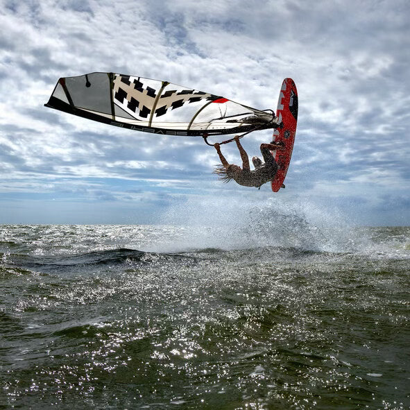 freestyle windsurfer, hoge sprong, rood board, zwart met wit zeil, zonnig weer