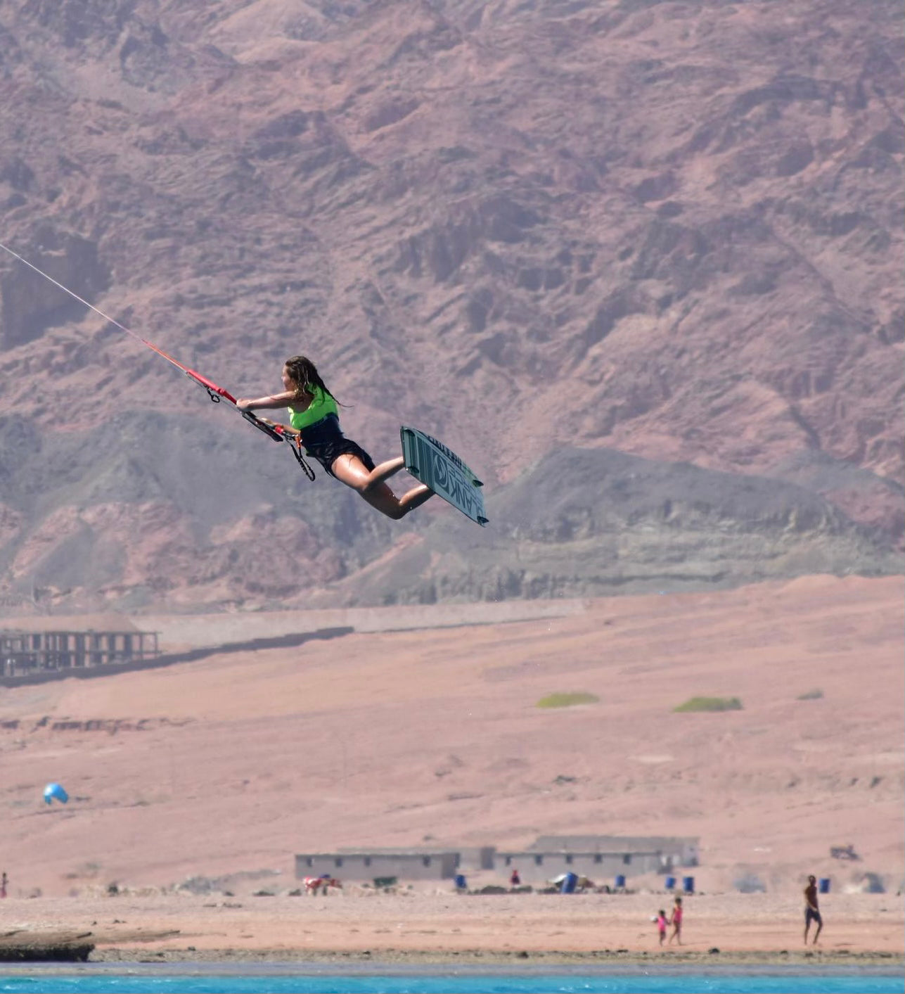 Kitesurfer, geel zwemvet, hoge sprong, bergen